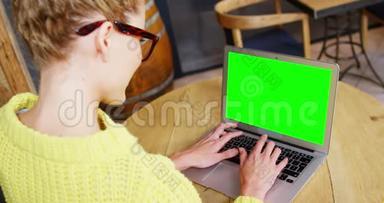 坐在桌子上的女人用笔记本电脑